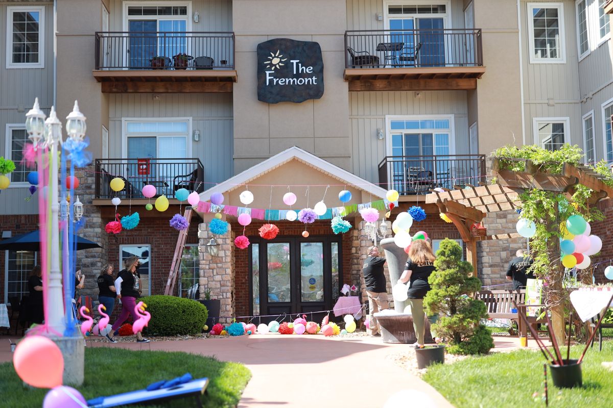 The entrance of a building decorated with colorful balloons for a celebration.
