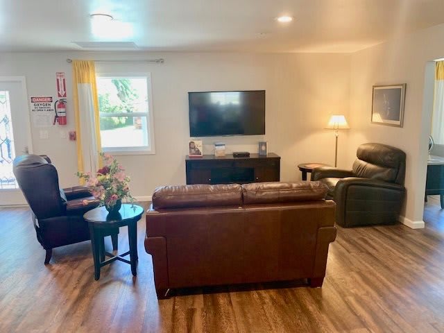 A cozy living room with comfortable seating, a television, and warm lighting.