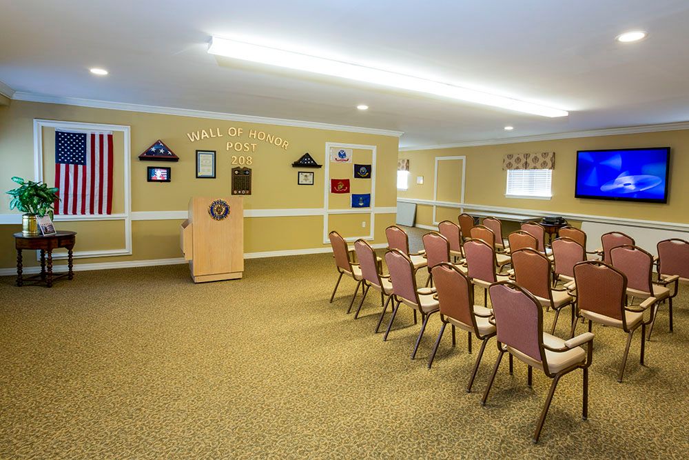 A conference room with rows of chairs facing a podium.