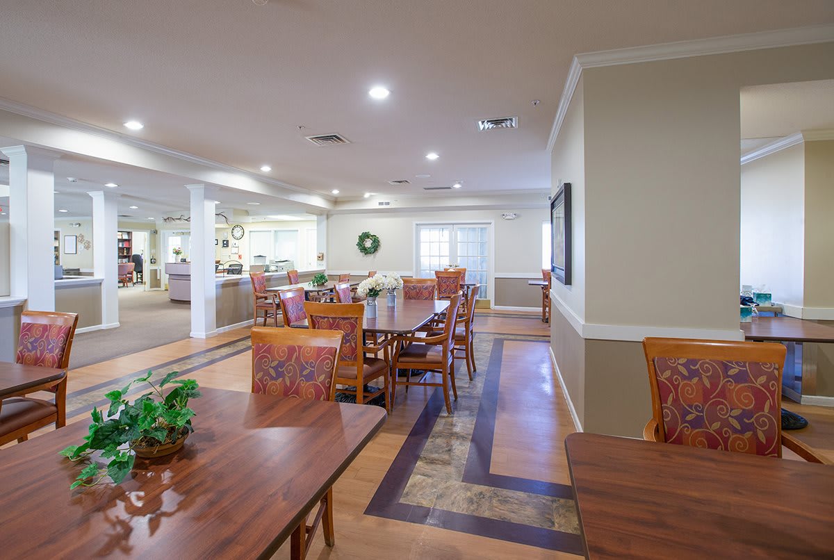 A well-lit dining area with neatly arranged tables and chairs.