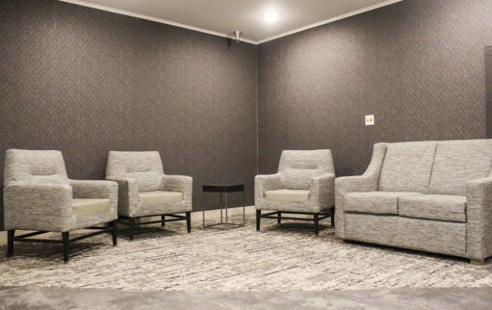 A minimalist living room with modern chairs and a patterned carpet.