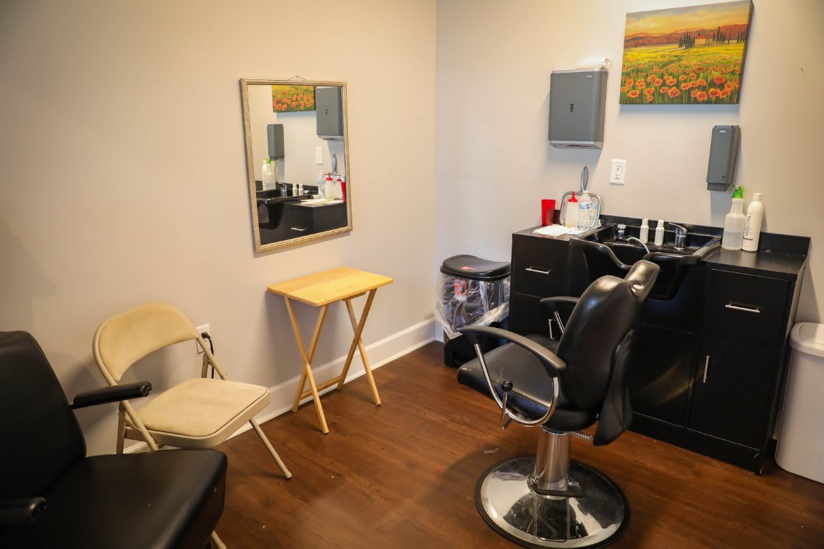 A neat and well-organized hair salon with a styling station and waiting area.