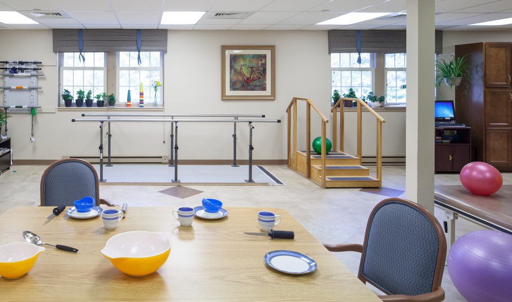 A physical therapy room equipped with parallel bars and training stairs, set up for rehabilitation exercises.