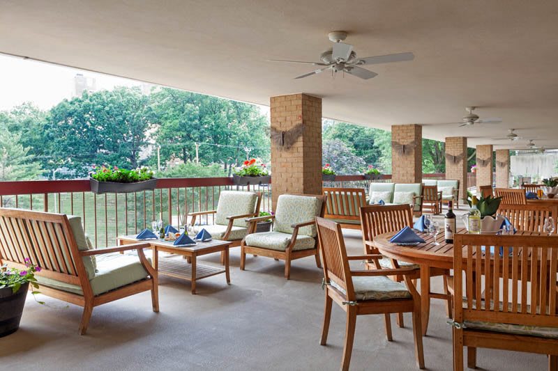 An inviting outdoor patio with comfortable seating and a view of lush greenery.