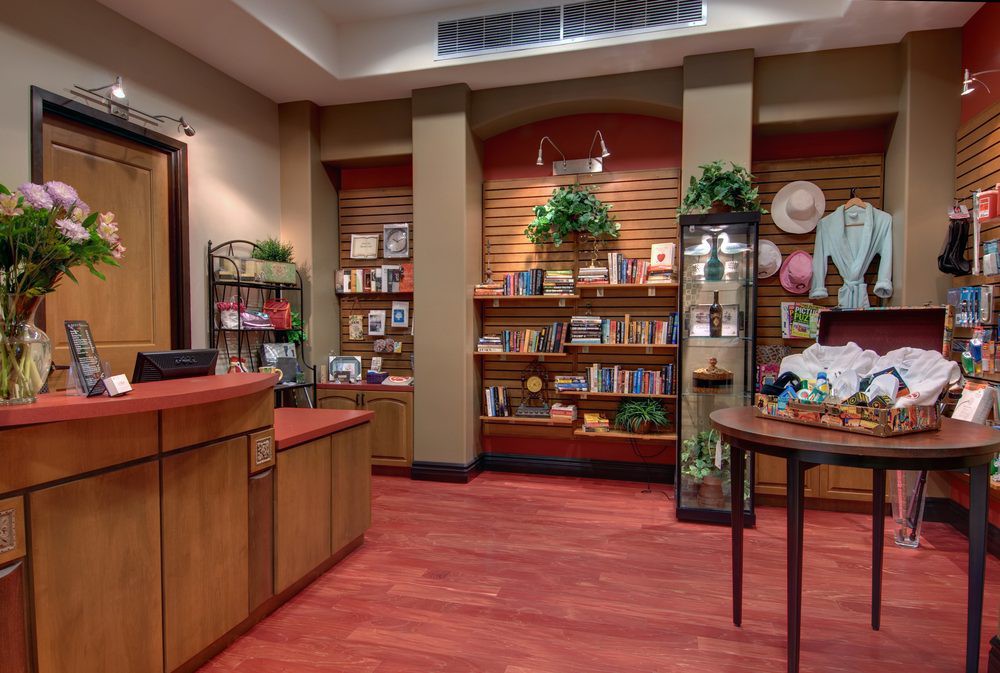 A cozy bookstore interior with shelves of books and gifts, decorated with plants.