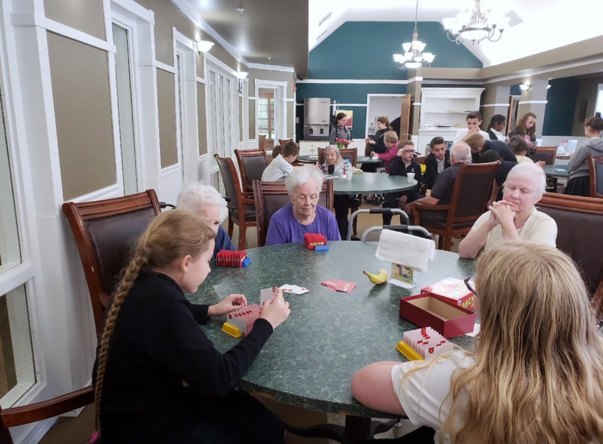 A group of seniors enjoying a card game together in a community setting.