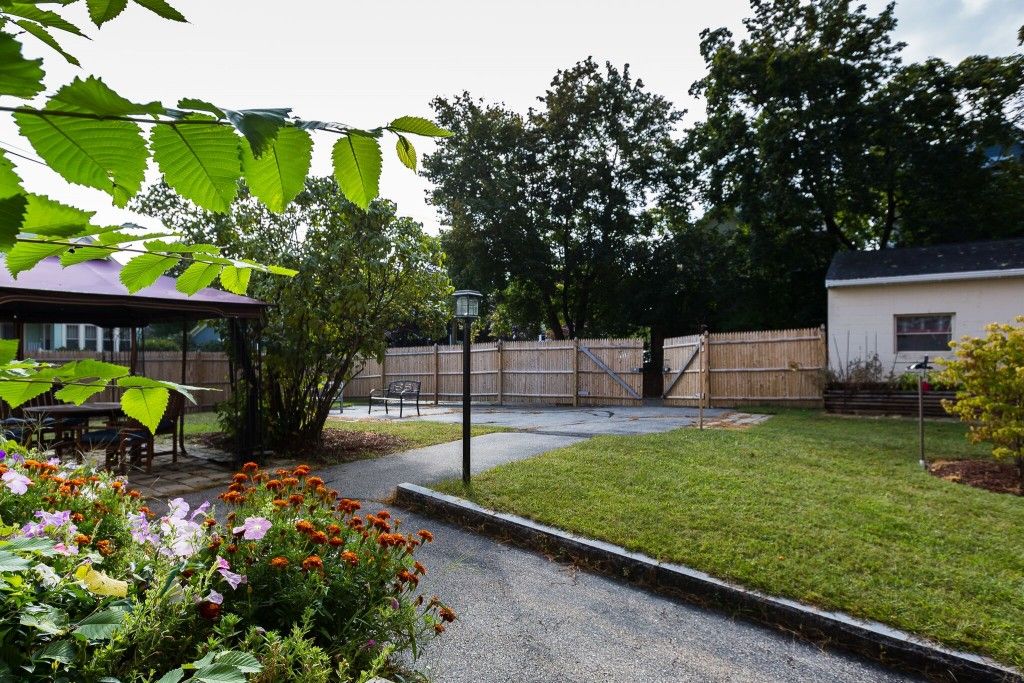 A serene garden with a pathway, vibrant flowers, and lush greenery.
