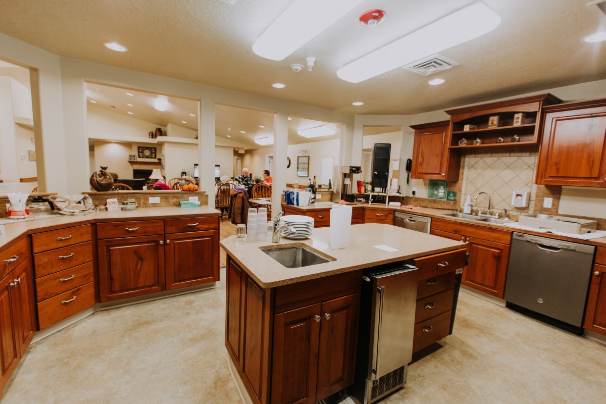 A spacious kitchen with a central island and wooden cabinets.