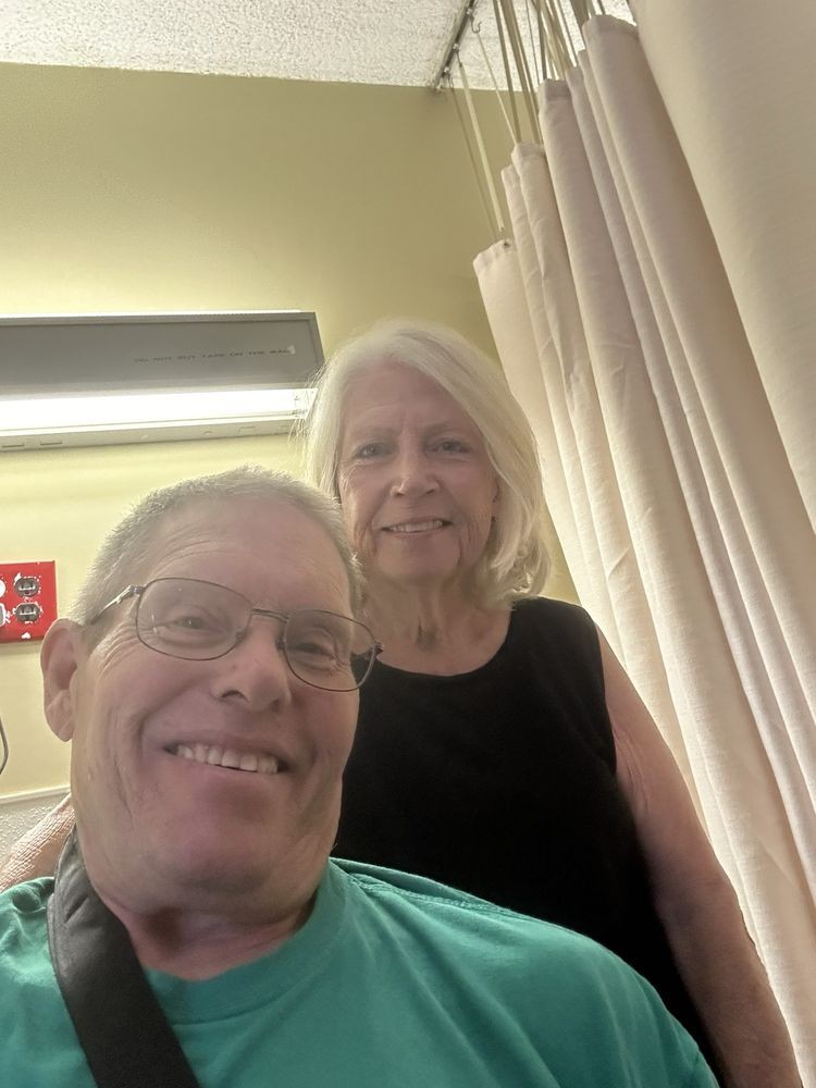 A smiling couple takes a selfie indoors.
