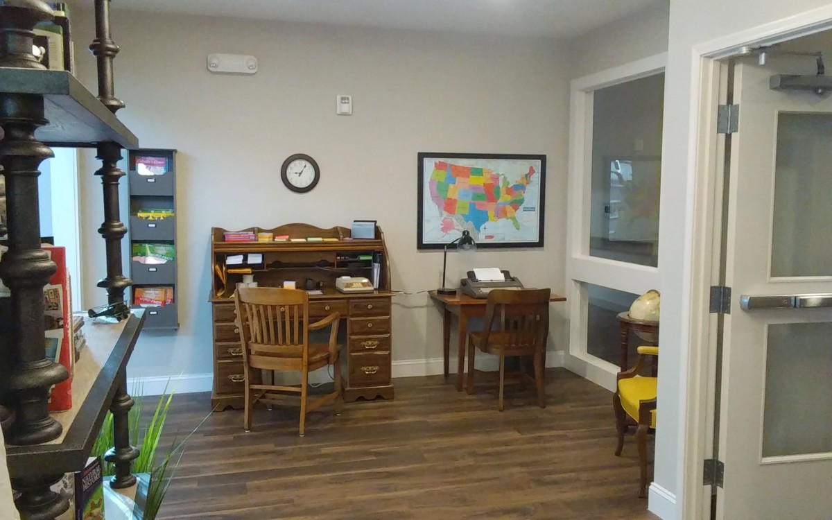 A neatly organized study area with wooden desks and a map on the wall.