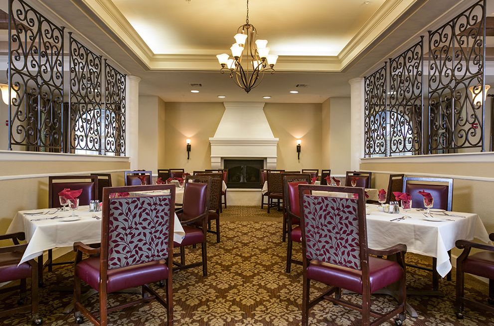 Elegant dining room with a classic interior design featuring chandeliers and ornate chairs.