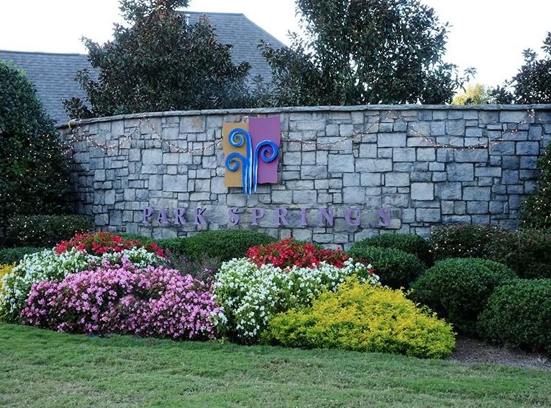 A beautifully landscaped garden with colorful flowers in front of a brick wall.