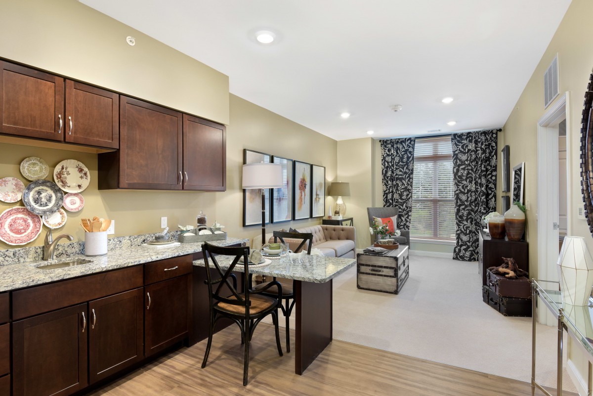 A cozy living space with an open floor plan, featuring a kitchen and dining area alongside a furnished living room.