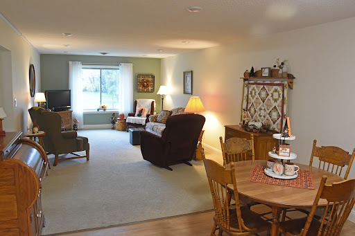A cozy and inviting living room with a dining area, featuring comfortable seating and warm lighting.