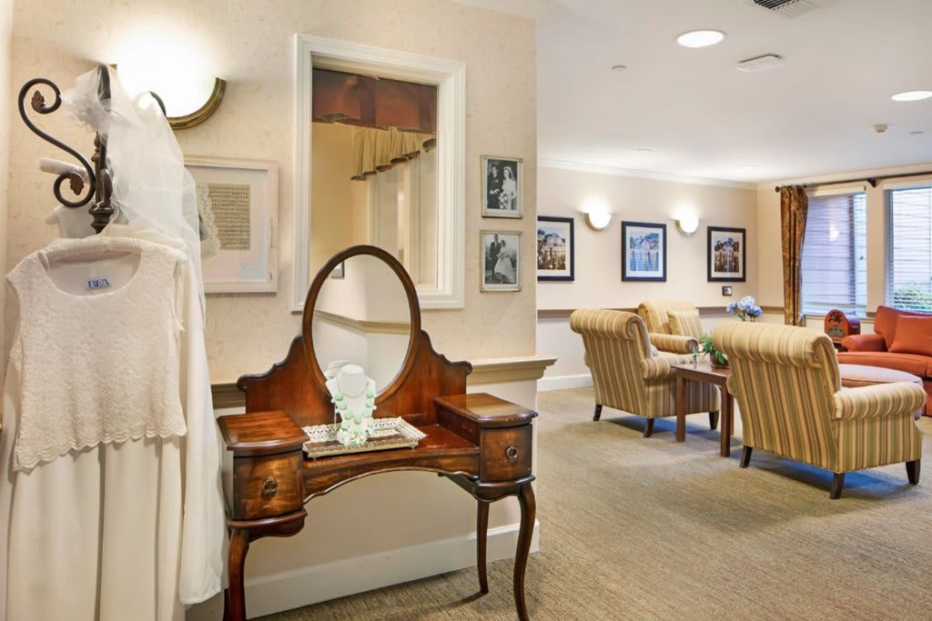An elegantly decorated room featuring vintage furniture and framed artwork.