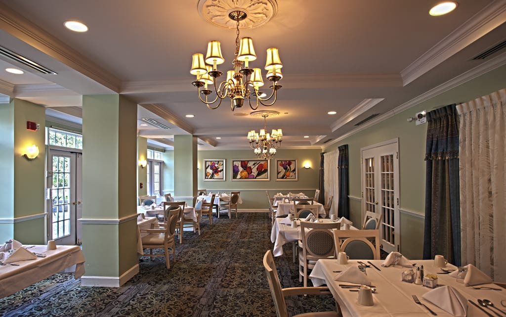 An elegant restaurant dining area with neatly arranged tables and chandeliers.