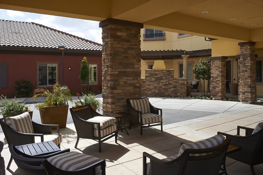 A cozy outdoor patio area with comfortable seating and architectural features.