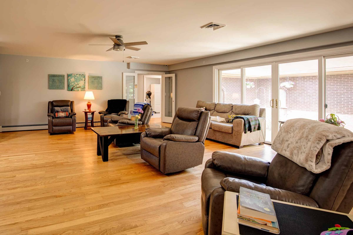 A spacious living room with comfortable seating and large windows allowing natural light.