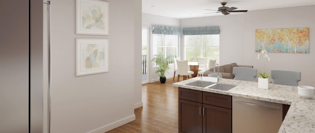 A modern kitchen and dining area with ample natural light and wooden flooring.