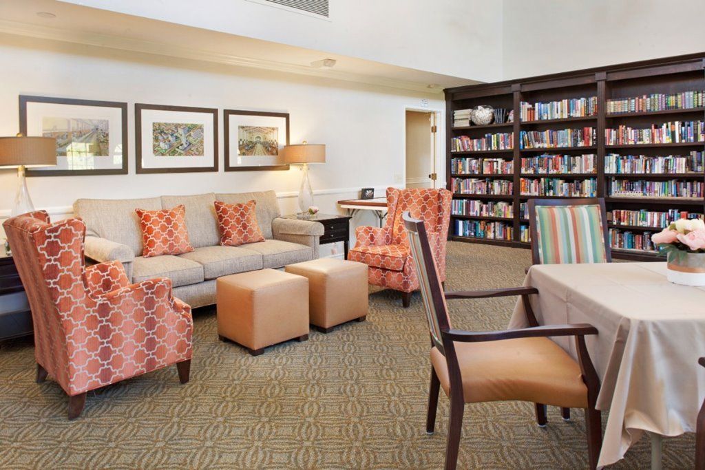 A cozy living room with bookshelves, comfortable seating, and decorative elements.