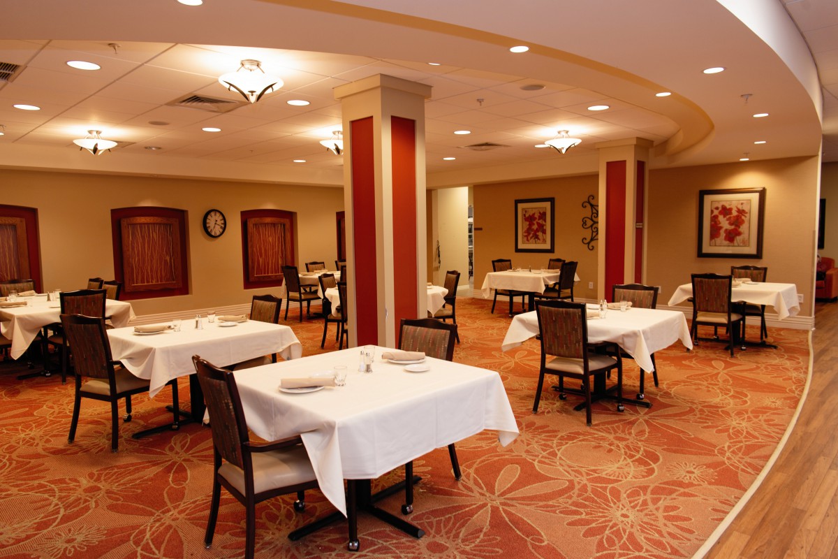 An empty restaurant dining room with neatly arranged tables and chairs.