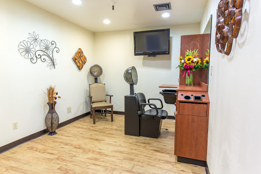 A modern hair salon interior featuring comfortable seating and decorative elements.