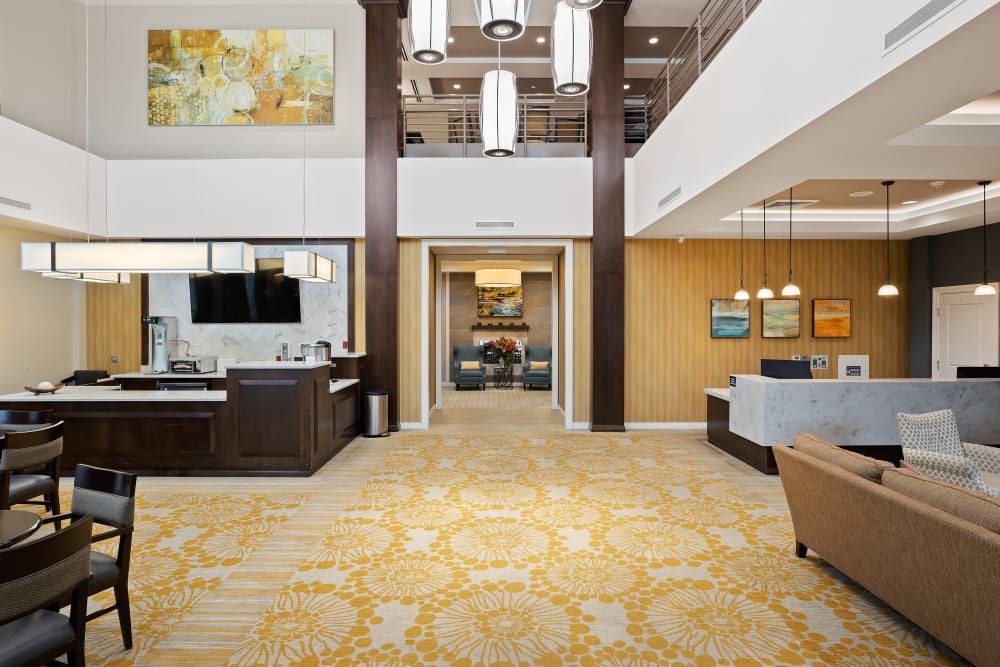 A modern hotel lobby with elegant interior design featuring a reception desk, comfortable seating, and contemporary lighting.