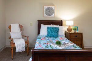 Cozy bedroom with a single bed, floral bedding, and a decorative pillow.