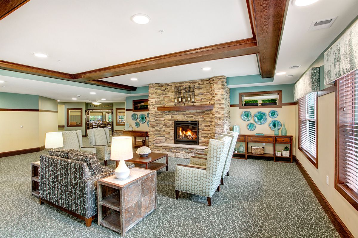 A cozy living room with a stone fireplace and comfortable seating.