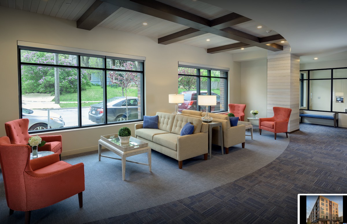 A modern waiting room with comfortable seating and large windows.