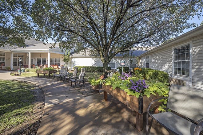 A serene outdoor garden area with seating and lush greenery.