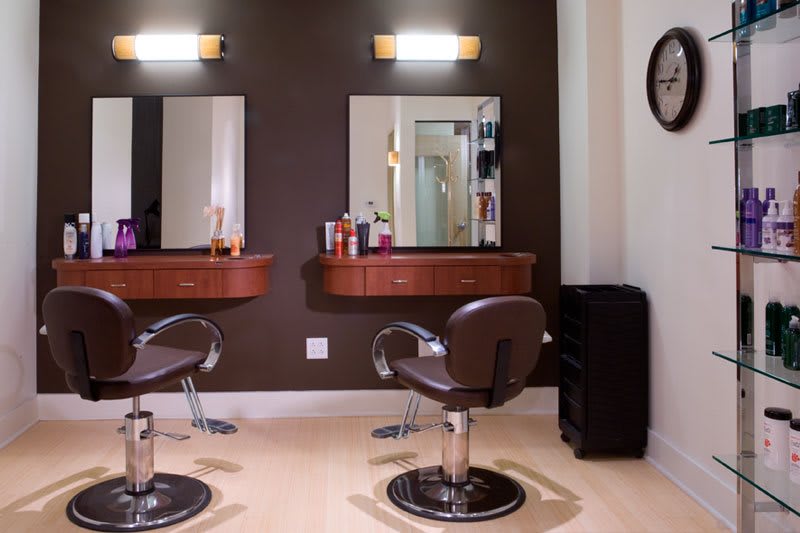 A well-organized hair salon with two styling stations featuring comfortable chairs and mirrors.