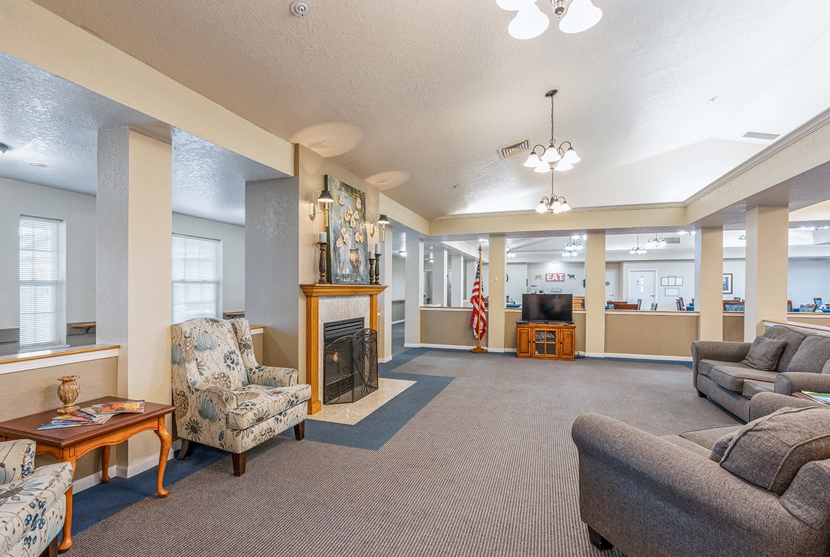 A spacious living room with a fireplace, seating area, and television.