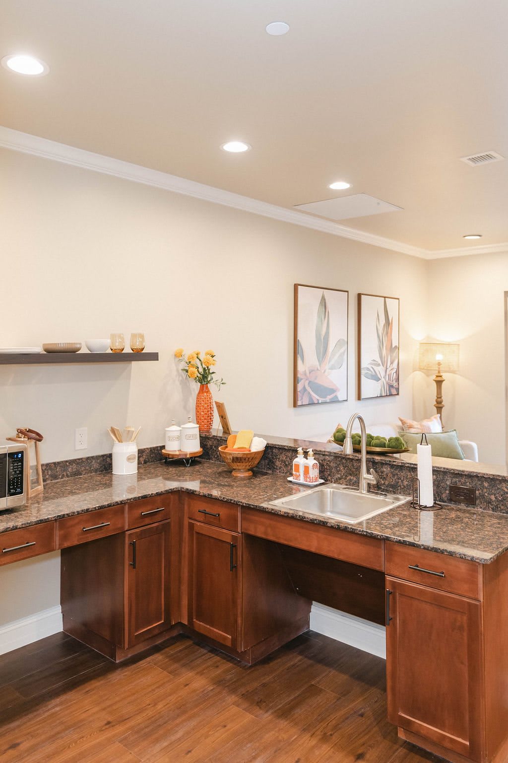 A modern kitchen with wooden cabinets, a large countertop, and various decor items.