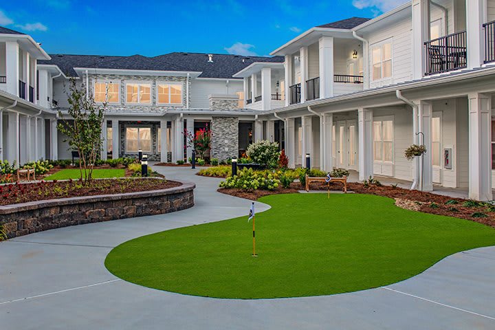 A modern luxury house with well-maintained landscaping and a spacious outdoor area.
