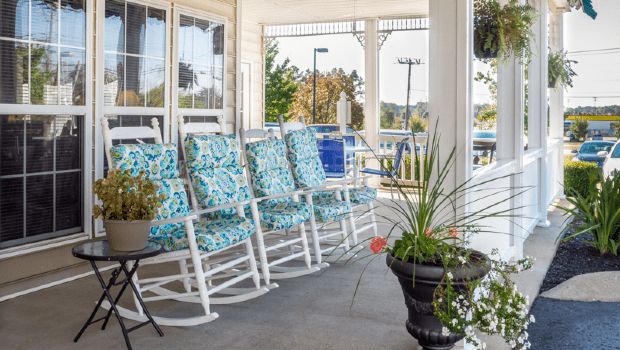 A cozy porch area with patterned rocking chairs and decorative plants.