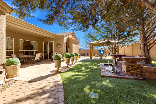 A serene backyard space featuring well-maintained greenery and a cozy seating area.