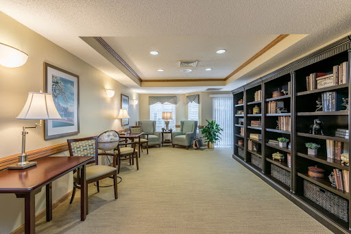 A cozy and well-lit lounge area featuring comfortable seating and bookshelves, perfect for reading or relaxation.