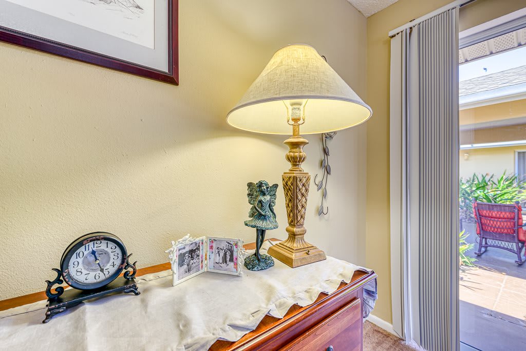 A cozy indoor setup featuring a table lamp, decorative items, and photo frames.