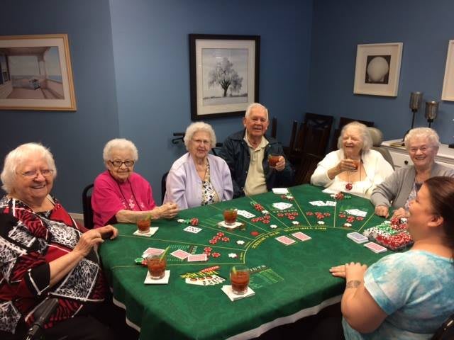 A group of seniors enjoying a card game together indoors.