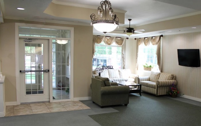 A cozy living room with comfortable seating, elegant chandelier, and ample natural light.