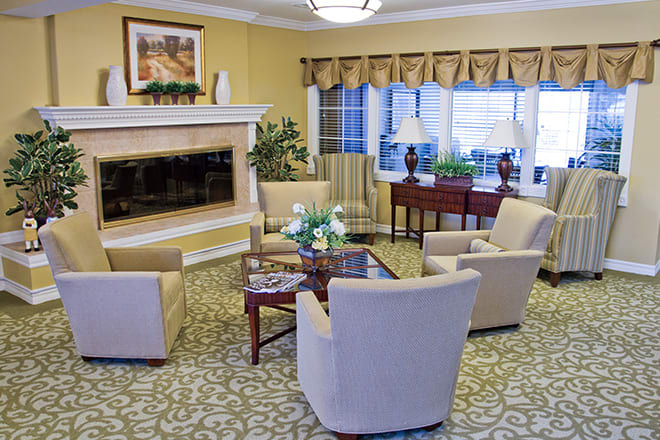 A cozy living room with elegant furniture and a fireplace, featuring a well-arranged seating area.