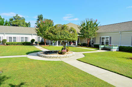 A well-maintained courtyard with a central tree, surrounded by pathways and lawns.