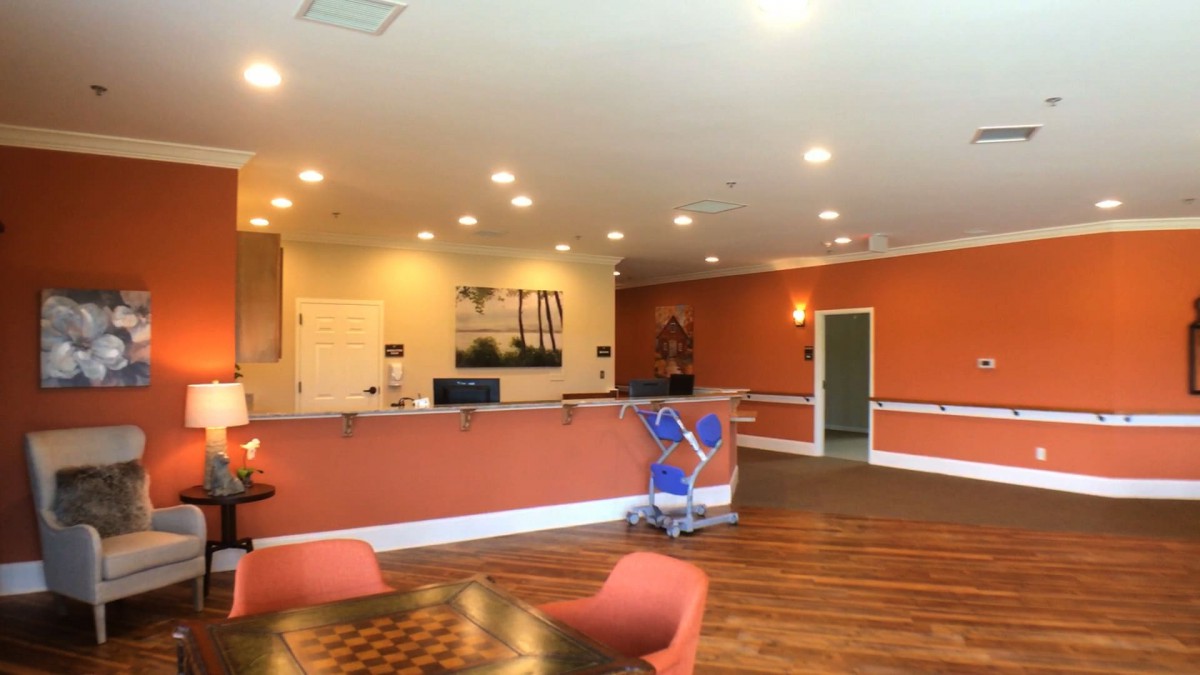 A spacious reception area with a desk, chairs, and warm lighting.
