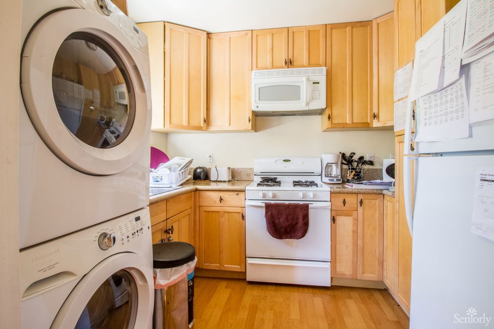 A cozy kitchen with wooden cabinets and integrated laundry appliances.