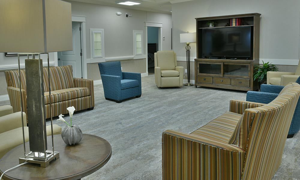 A modern living room with various seating options and a large television.