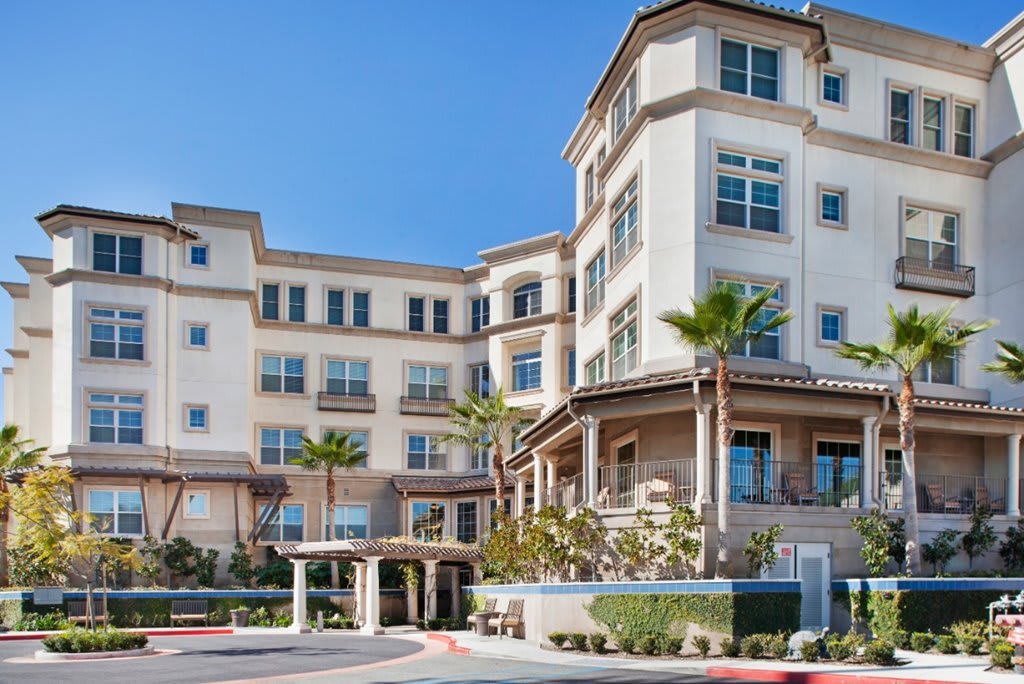 A modern residential building with palm trees in front.