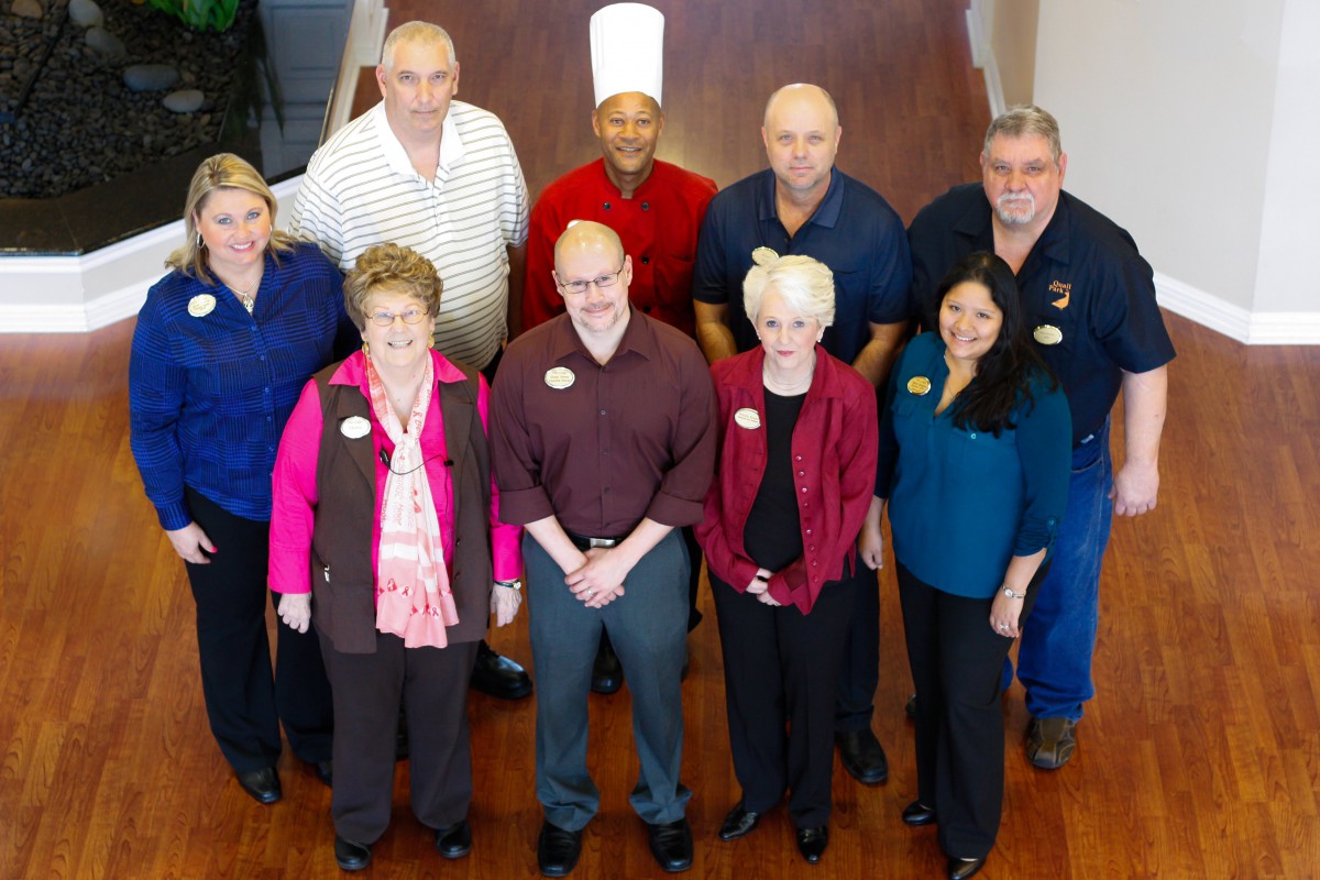 A group of professionals posing together indoors, some in uniforms.