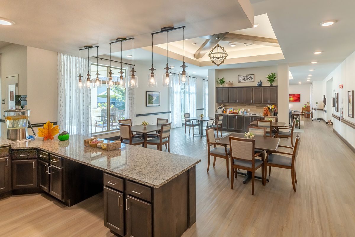 A spacious and modern open concept kitchen and dining area with stylish lighting fixtures.