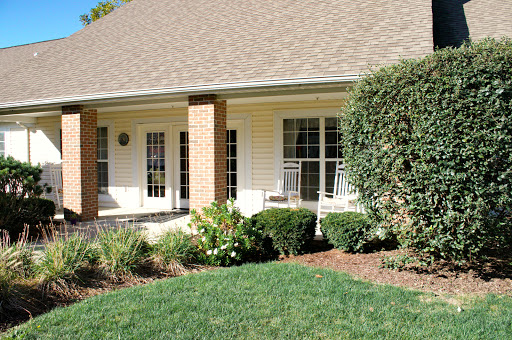A charming house with a welcoming front porch and well-maintained landscaping.
